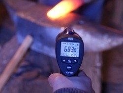 Mesureur de température sans contact mesurant la température à l'intérieur d'un tableau électrique.
